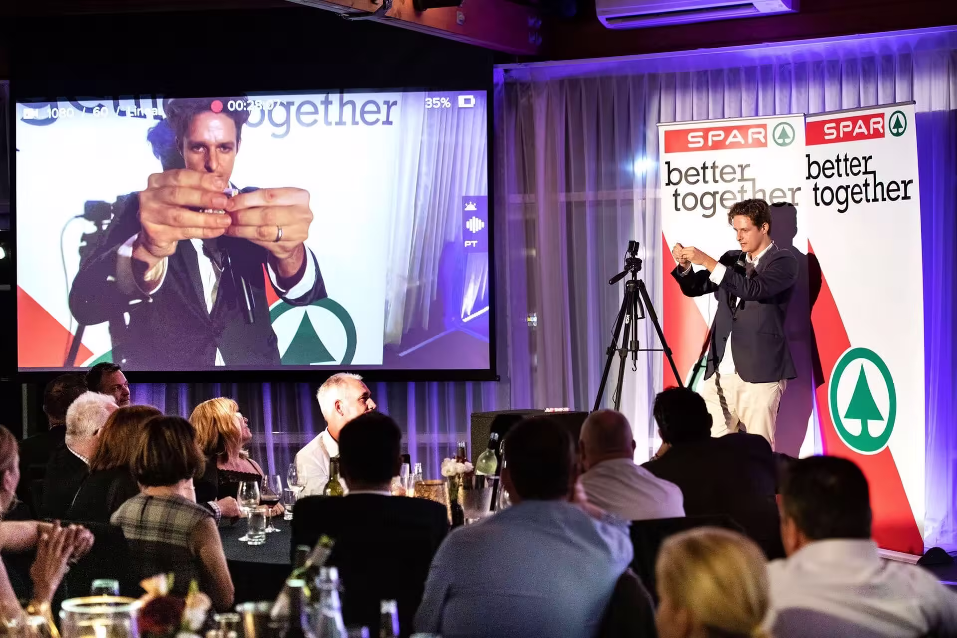 Jason Gray on stage delivering a comedy magic show